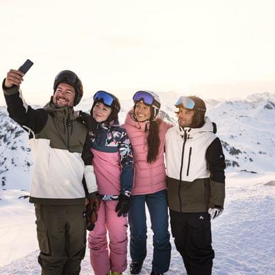 Group of friends taking a selfie while skiing in snowy alpine mountains